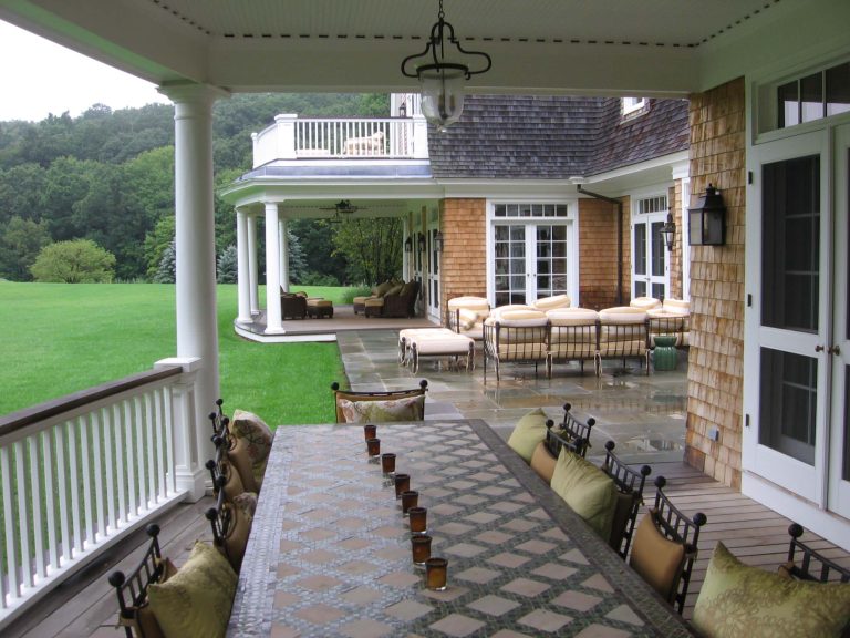 Rainy day under the porches, the central stone porch connects the two covered wood decks. The furniture has a Moroccan theme with deep cushions and muted colors. by Studio 511 | Outdoor Photos | Porch | Landscaping | Landscape Design | Outdoor Living Space | Porch Design Ideas | Outdoor Living Space Ideas | Backyard Design