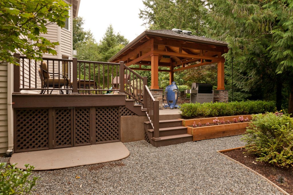 Raised patio allows for stepped planters. Concrete storage pad under deck allows for lawn equipment storage.