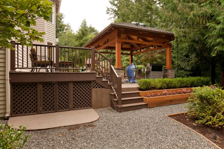 Raised patio allows for stepped planters. Concrete storage pad under deck allows for lawn equipment storage.
