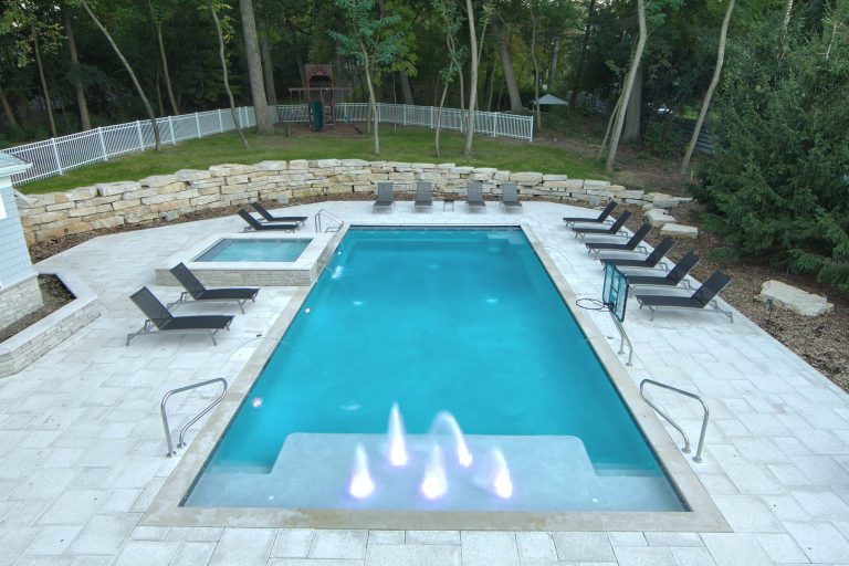 Request Free Quote Pool and spa with a waterfall, water jets, and a sun shelf.