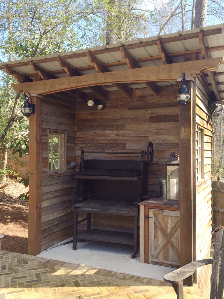 Rustic style barbecue shed designed and built by Atlanta Decking & Fence. Back side serves as extra storage.