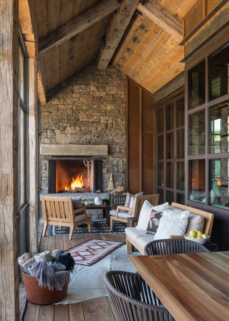 Screened porch with outdoor fireplace. Steel windows into living space, Photos By Audrey Hall