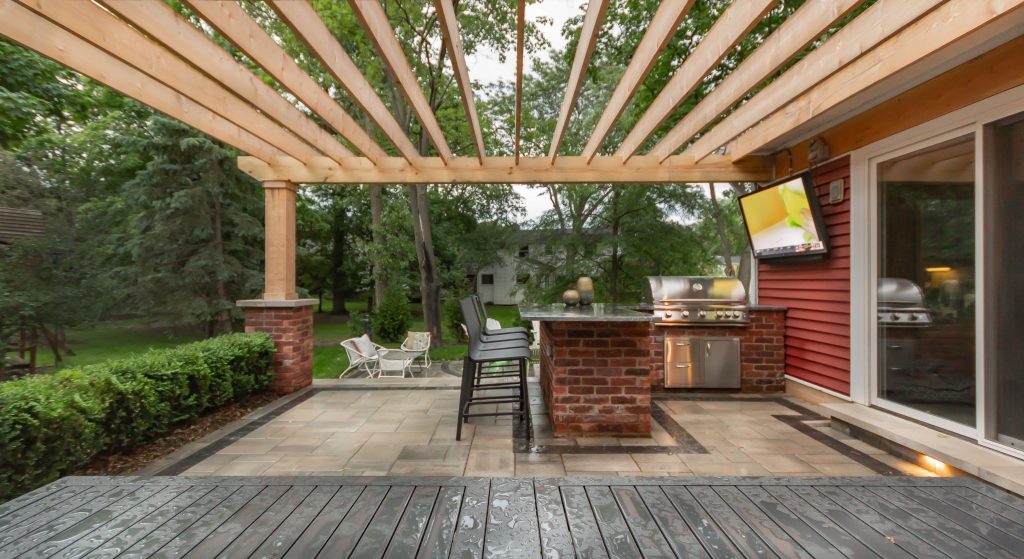 Small arts and crafts backyard brick patio kitchen photo in Detroit with a pergola