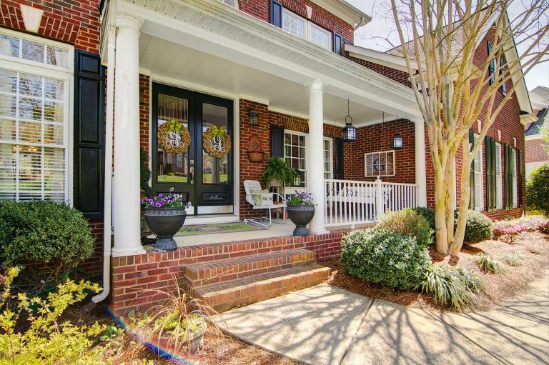 Small beach style concrete front porch photo in Charlotte with a roof extension by Angie Guy Design | Outdoor Photos | Porch | Landscaping | Landscape Design | Outdoor Living Space | Porch Design Ideas | Outdoor Living Space Ideas | Backyard Design