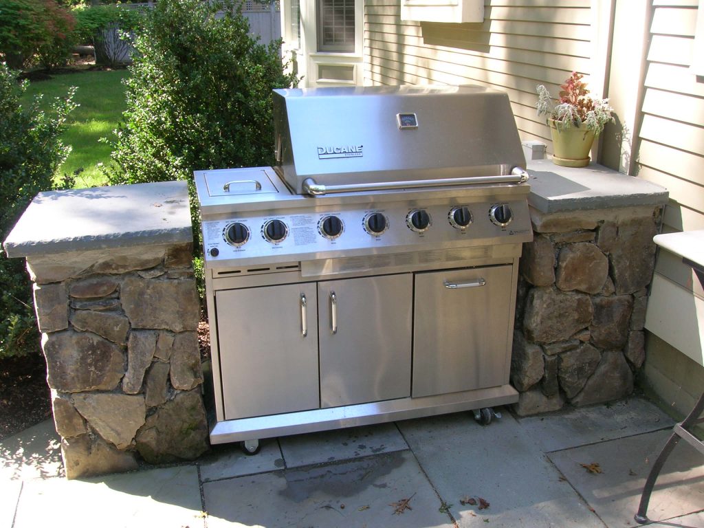 Small elegant backyard stone patio kitchen photo in Boston with no cover