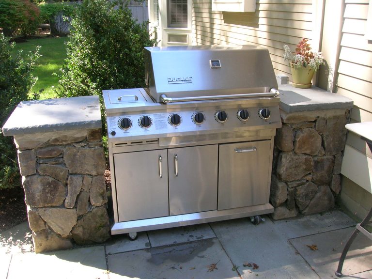Small elegant backyard stone patio kitchen photo in Boston with no cover