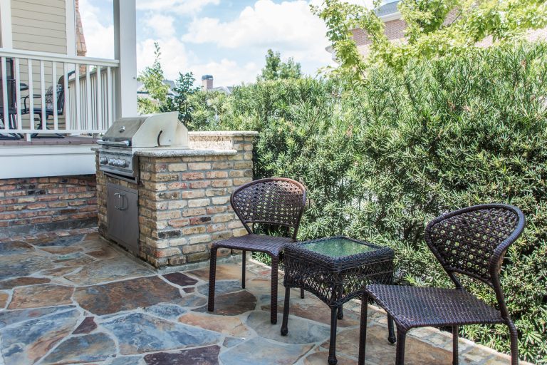 Small elegant backyard stone patio kitchen photo in Houston