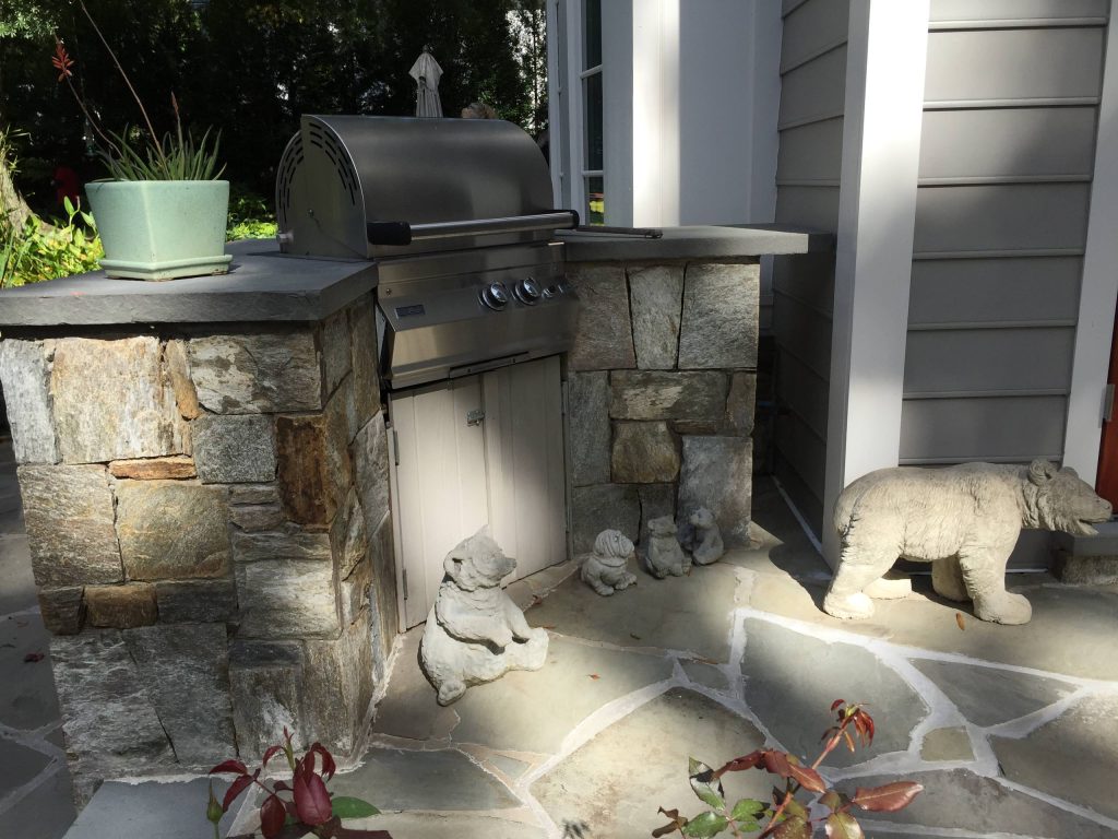 Small elegant backyard stone patio kitchen photo in New York with no cover