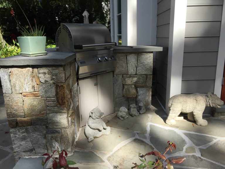 Small elegant backyard stone patio kitchen photo in New York with no cover