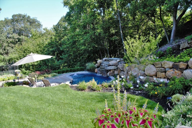Small mountain style backyard stone and kidney-shaped natural pool fountain photo in New York