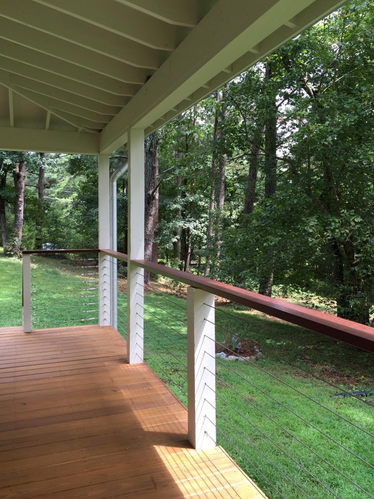 South-facing front porch with cable railings and mahogany handrail.