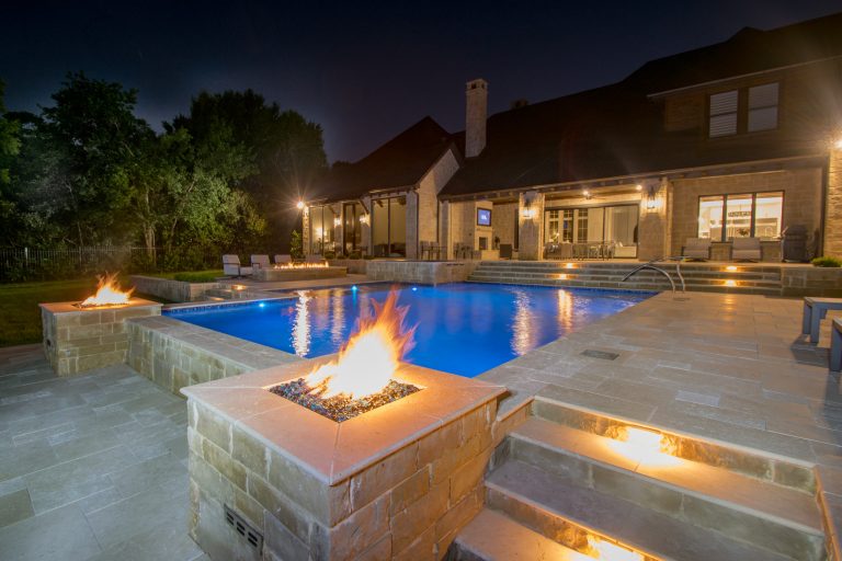 Southlake gorgeous swimming pool project designed by Mike Farley - Silver travertine, fire bar, sheer descents, rolled edge spa & more! FarleyPoolDesigns.com