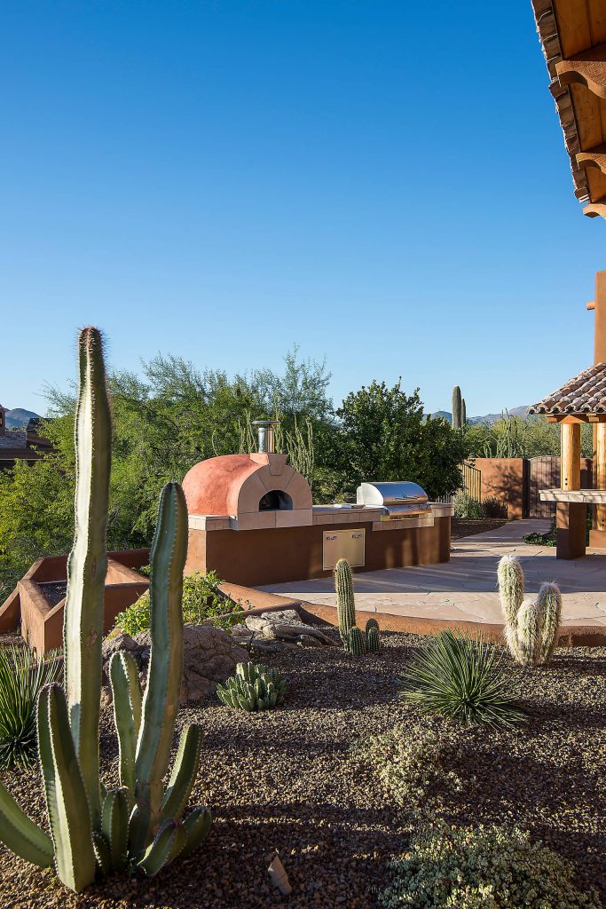 Southwest backyard stone patio kitchen photo in Phoenix