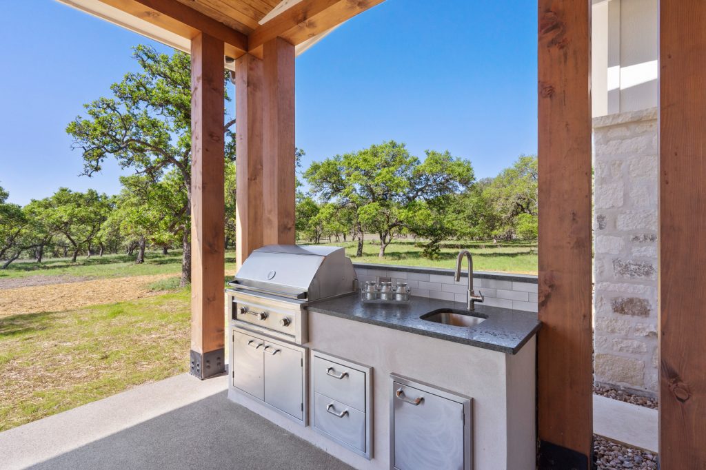Spacious outdoor living area equipped with gas grill, undermount sink and built in storage with slip proof epoxy porch.