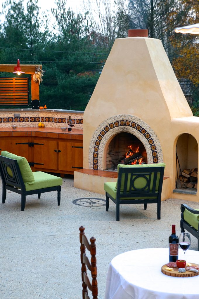 Spanish mission style patio with a fireplace and outdoor kitchen. Pete Cooper/Spring Creek Design