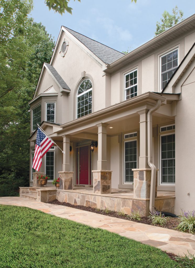 Stately front porch boasts stone piers (column bases), steps, stoop and sidewalk.