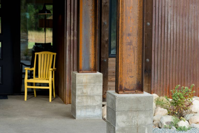 Steel column detail. Board formed concrete base. Photography by Lucas Henning.
