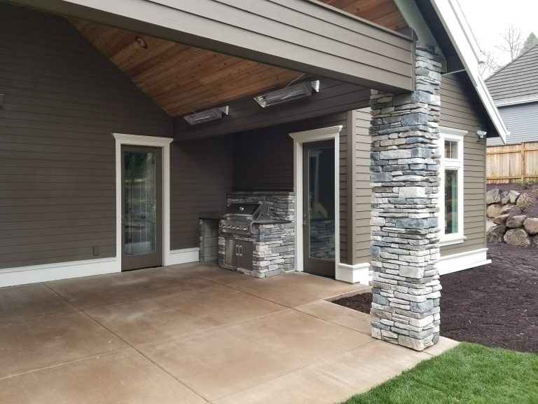 Stone veneer in outdoor living. Stone columns, veneered gas grill enclosure and outdoor fireplace.