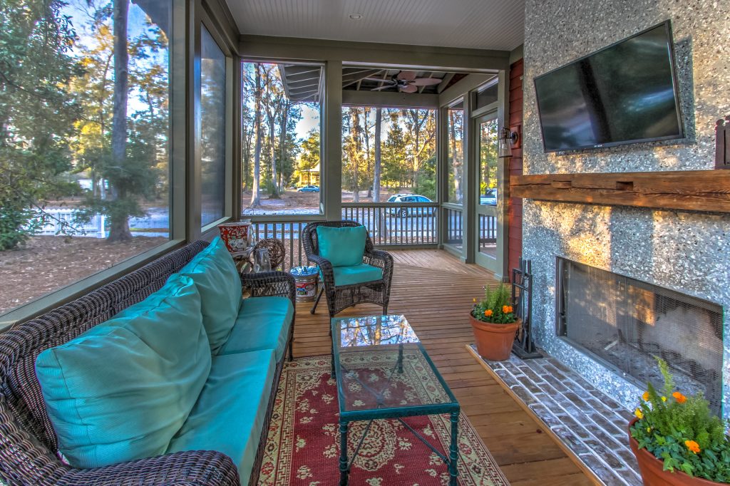 Tabby shell and brick fireplace with rustic beam mantle warm the quaint outdoor living space