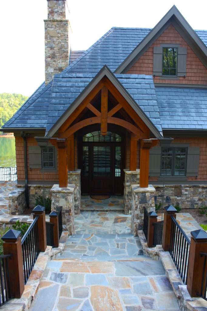Tapered stone bases support timber columns and truss work at the entry.