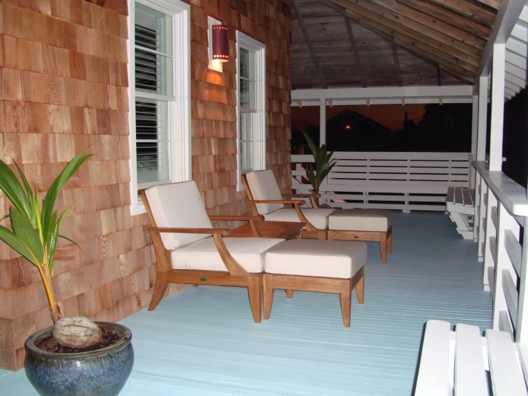 Teak lounge chairs and side table on porch of customized historic renovation by Charley Pereira, Beach Design & Construction, Inc.
