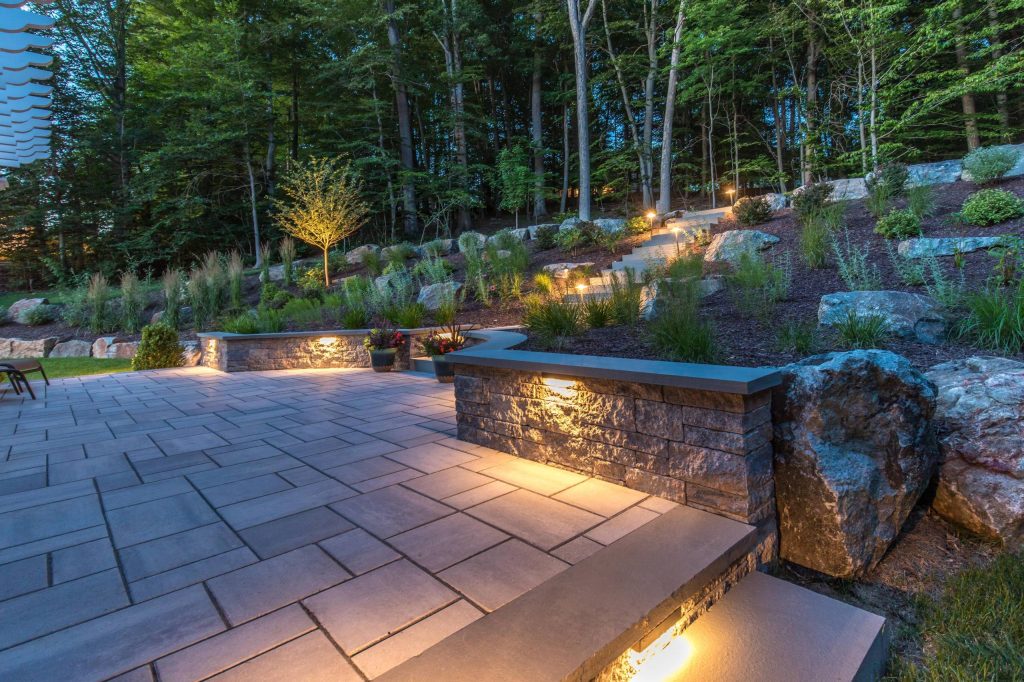 Terraced backyard, complete with Techo-Bloc patio, pergola, landscape lighting and flowing landscape!