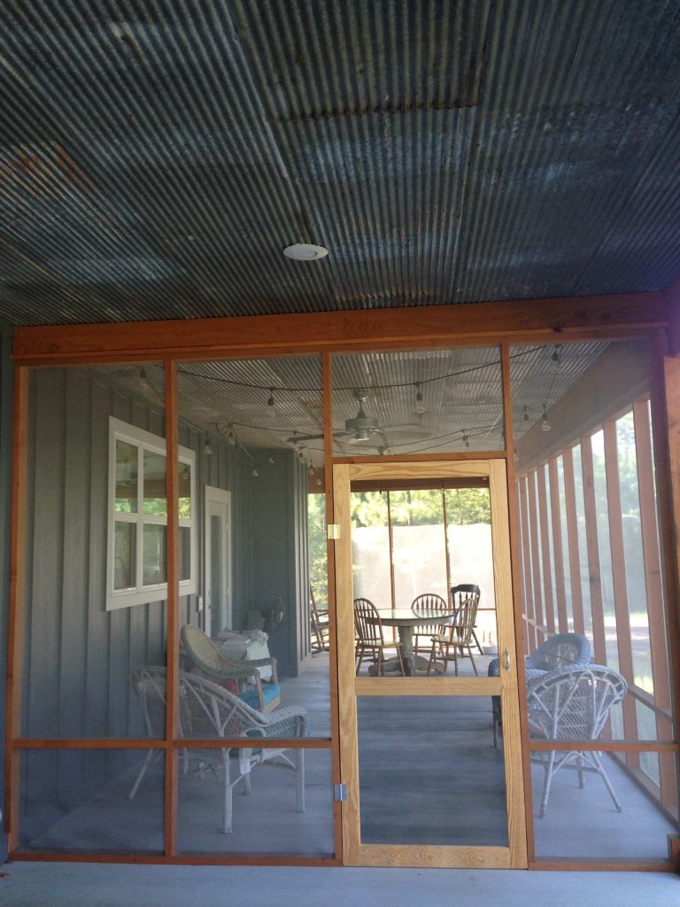 The 12' x 30' fir-framed screen porch features a barn tin ceiling