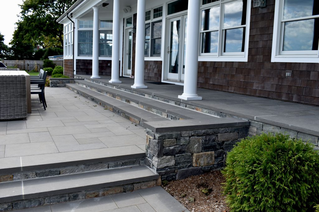 The back porch was re-surfaced with bluestone to match the new patios and walks. Narrow steps were replaced with wide new steps with generous bluestion treads.