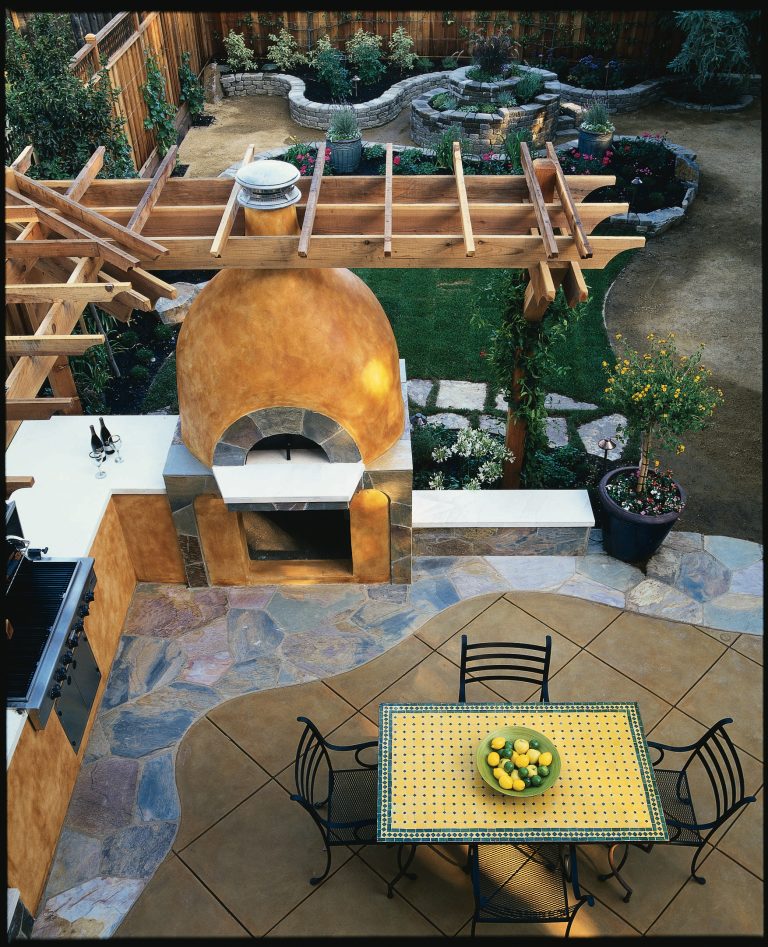 The backyard features a pizza oven with built-in seating, counter space and a grill for outdoor entertaining.