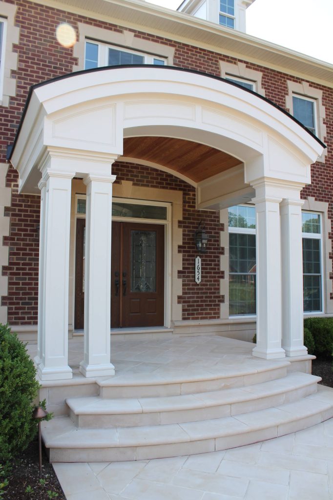 The barrel-vaulted front porch roof, curved dormers, and curved concrete steps all tie together the home's exterior. Columns and decorative moulding add a luxurious feel. by Synergy Design & Construction | Outdoor Photos | Porch | Landscaping | Landscape Design | Outdoor Living Space | Porch Design Ideas | Outdoor Living Space Ideas | Backyard Design