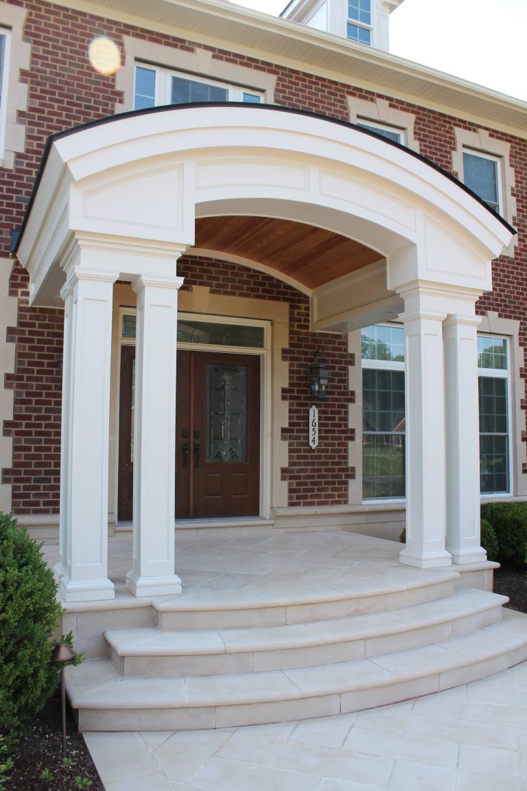 The barrel-vaulted front porch roof, curved dormers, and curved concrete steps all tie together the home's exterior. Columns and decorative moulding add a luxurious feel. by Synergy Design & Construction | Outdoor Photos | Porch | Landscaping | Landscape Design | Outdoor Living Space | Porch Design Ideas | Outdoor Living Space Ideas | Backyard Design