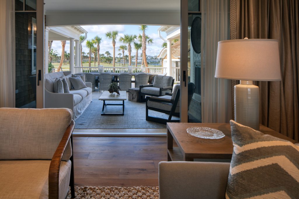 The brick and stone hearth fireplace is surrounded by cozy modern and transitional furniture