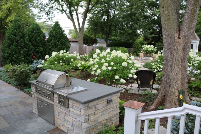 The built-in grill is topped with bluestone that has a thermal finish. The edge if rock faced. The gill island is clad in a mix of sandstone and limestone. Photo by Terra Jenkins and Kirsten Gentry