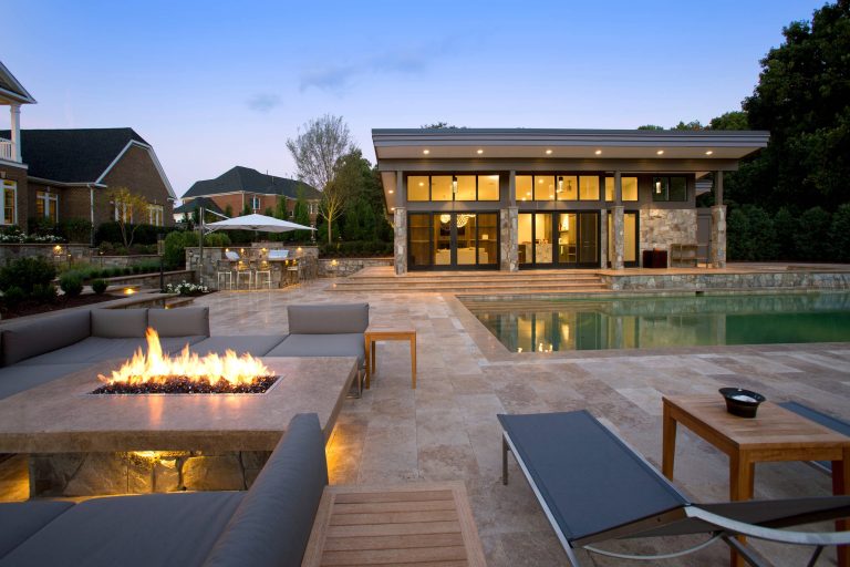 The contemporary pool house overlooks the pool and travertine pool deck, Landscape Architect: Howard Cohen. Surrounds Inc.
