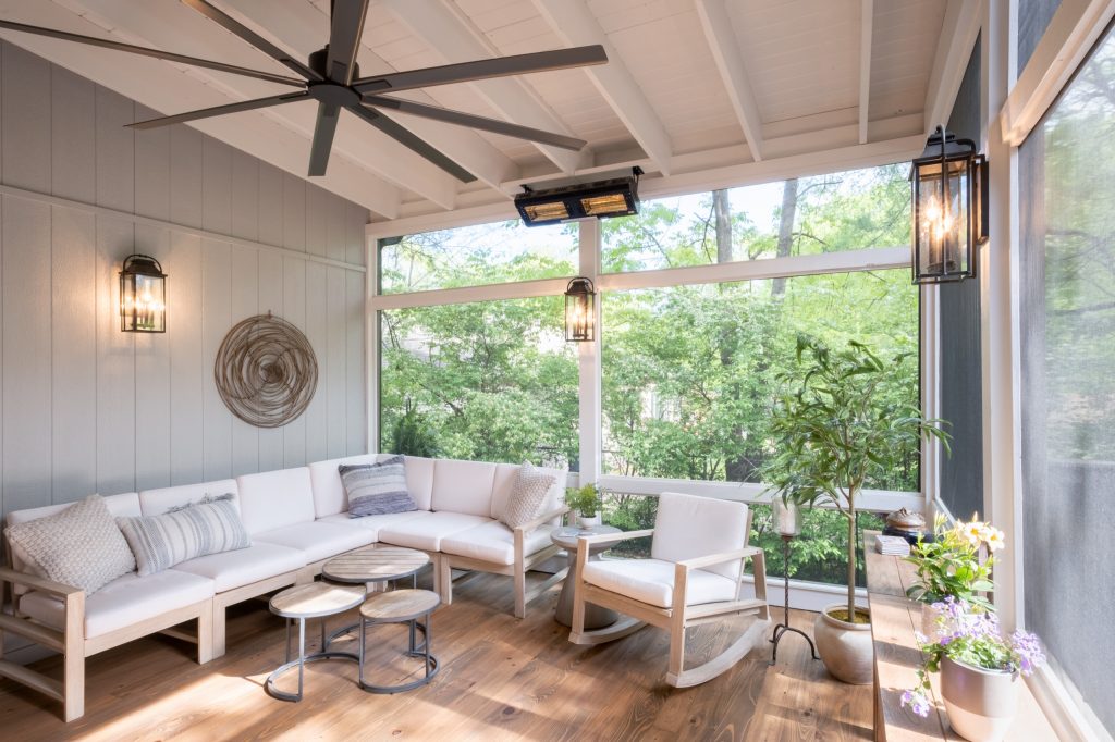 The cozy corner of the screen porch with full view of the surrounding greenery.
