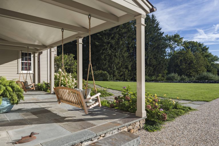 The entrance porch is paved in bluestone and features twin swings. Robert Benson Photography