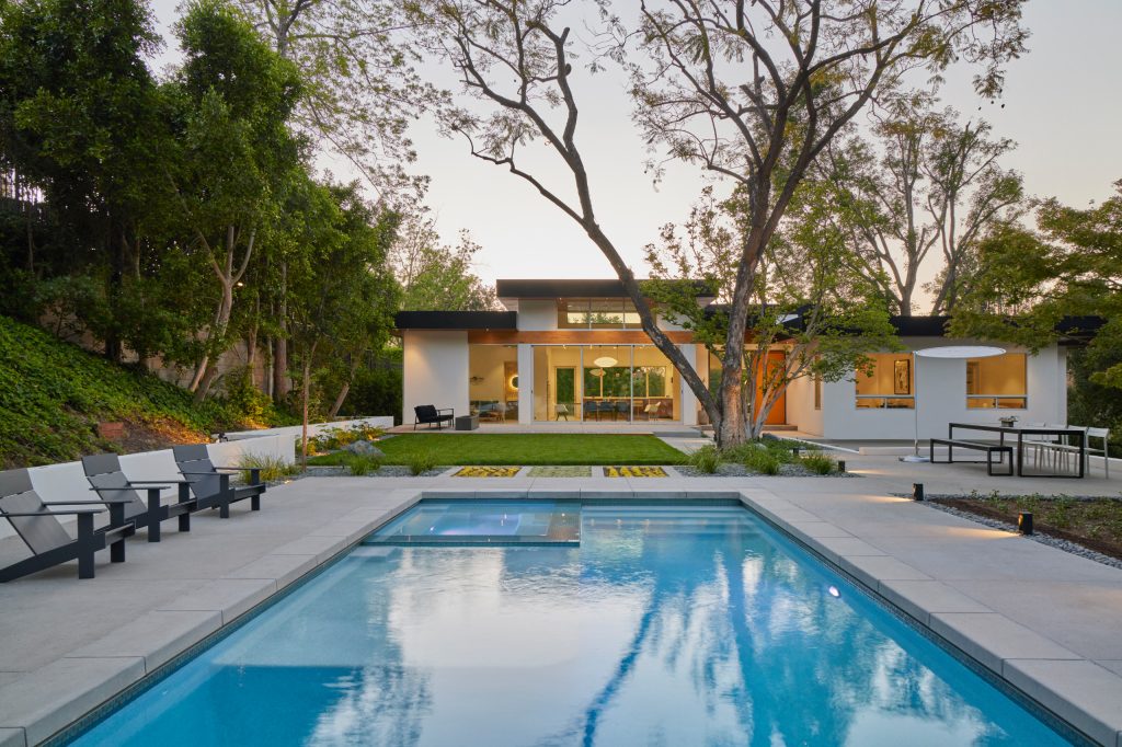 The exterior features black metal fascias wrapping exposed wood at the upper soffits. Select structural beams are exposed at key points to add warmth to the design.
