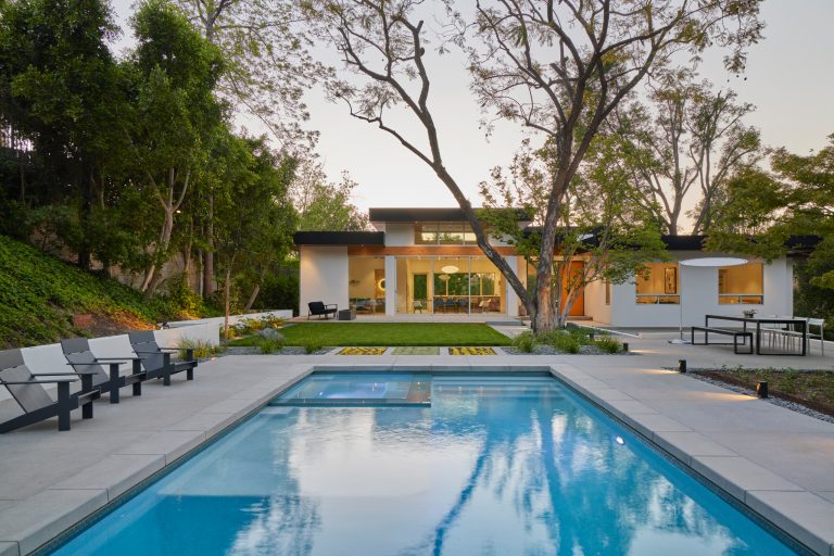 The exterior features black metal fascias wrapping exposed wood at the upper soffits. Select structural beams are exposed at key points to add warmth to the design.