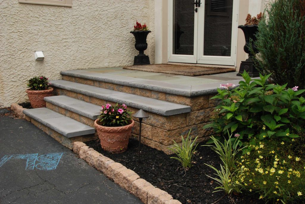 The front of the house has steps and a landing to match the paving on the back and side yards.