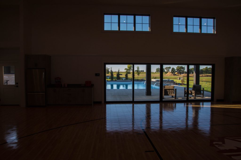 The home's pool features a wall of fountains and an adjacent pool house which plays double duty with an indoor basketball court.