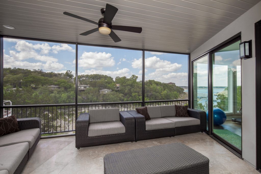 The insulated, angled glass of the rear facade faces north, an orientation that lends a head-on quality to views over the marina to the main body of the lake. Photo by Tre Dunham by Jenkins Custom Homes | Outdoor Photos | Porch | Landscaping | Landscape Design | Outdoor Living Space | Porch Design Ideas | Outdoor Living Space Ideas | Backyard Design