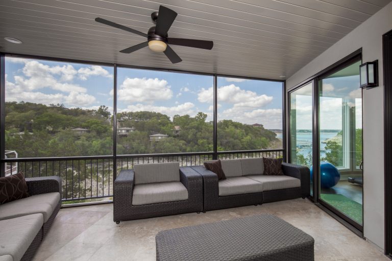 The insulated, angled glass of the rear facade faces north, an orientation that lends a head-on quality to views over the marina to the main body of the lake. Photo by Tre Dunham by Jenkins Custom Homes | Outdoor Photos | Porch | Landscaping | Landscape Design | Outdoor Living Space | Porch Design Ideas | Outdoor Living Space Ideas | Backyard Design