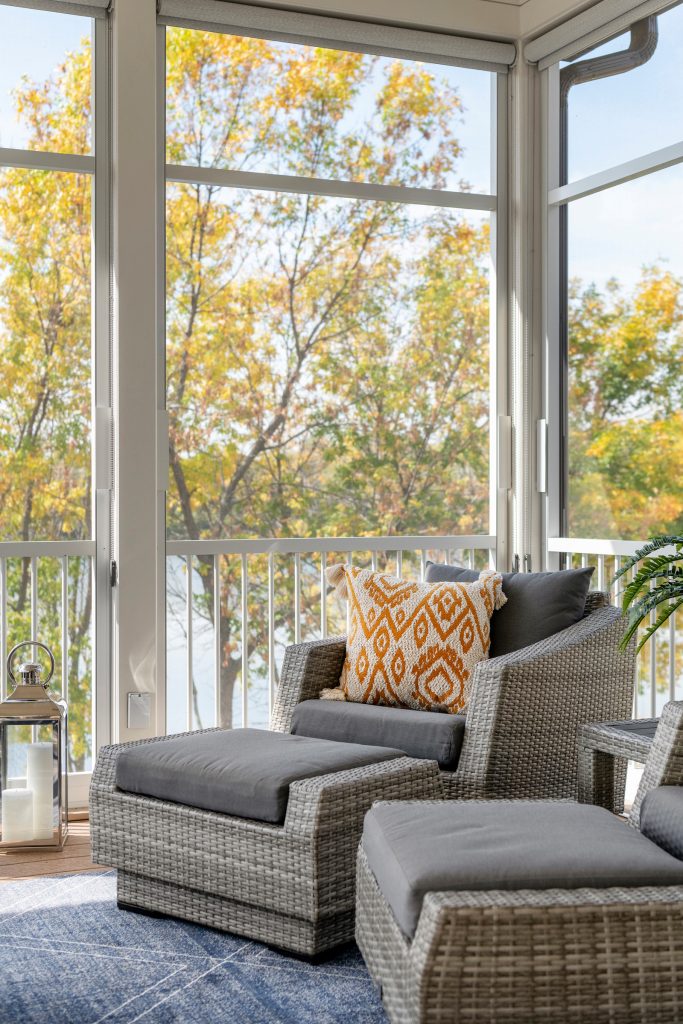 The inviting new porch addition features a stunning angled vault ceiling and walls of oversize windows that frame the picture-perfect backyard views. Photos by Spacecrafting Photography by Che Bella Interiors Design + Remodeling | Outdoor Photos | Porch | Landscaping | Landscape Design | Outdoor Living Space | Porch Design Ideas | Outdoor Living Space Ideas | Backyard Design
