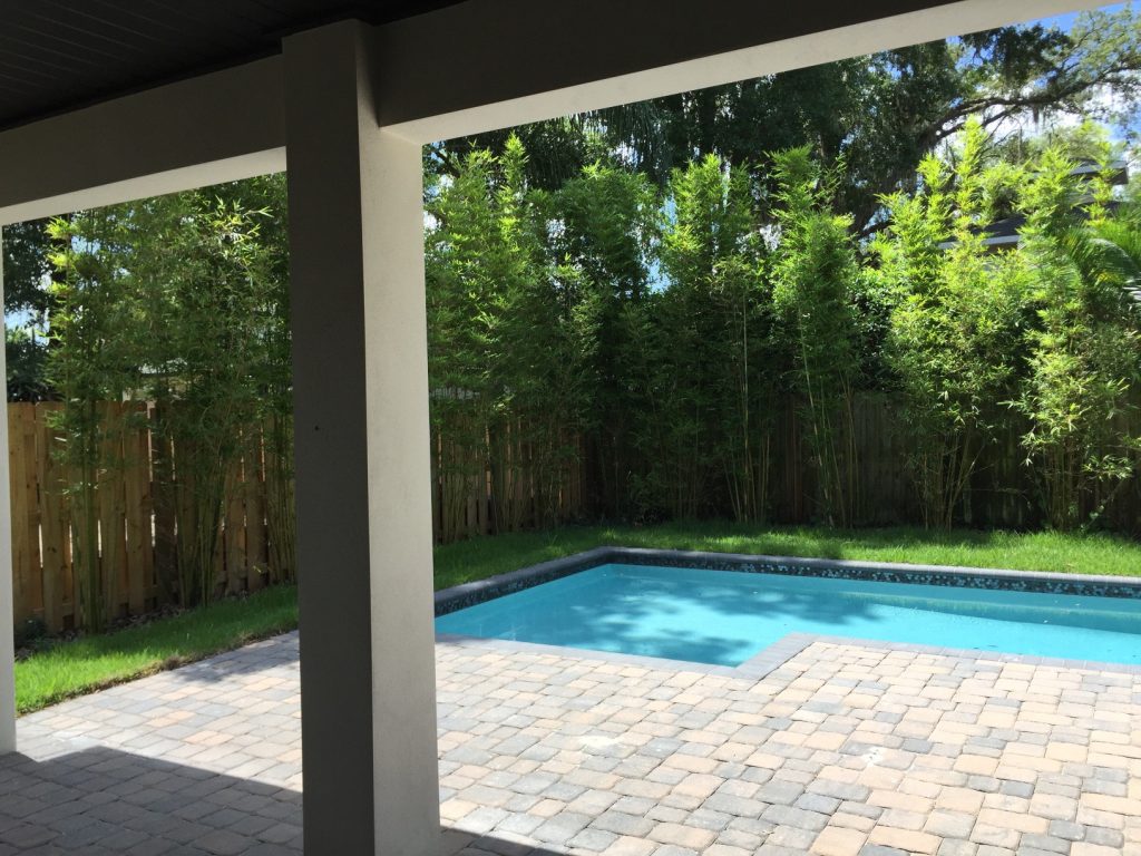 The knee wall to the left Center hides the A/C units and creeping fig vine was planted to cover the knee wall. The paver pool deck allows lots of space on this 50' wide lot by Meridian Homes | Outdoor Photos | Porch | Landscaping | Landscape Design | Outdoor Living Space | Porch Design Ideas | Outdoor Living Space Ideas | Backyard Design