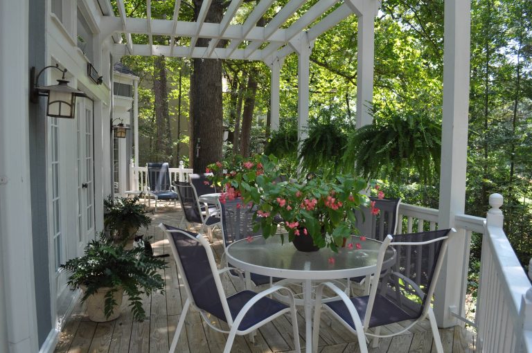 The large deck provides space for multiple tables and seating with an arbor above for light control.