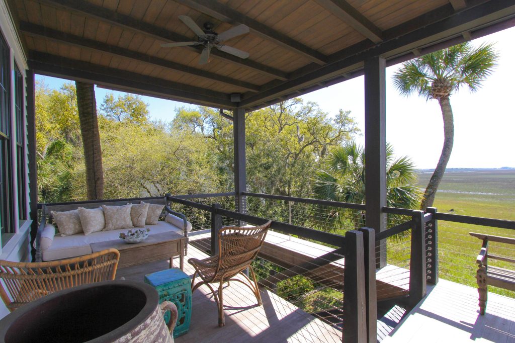 The large living room has doors that open onto the front porch creating a great flow for large gatherings and a beautiful setting on Conch Creek in Mount Pleasant. Listed by Elle Haynes. by William Means Real Estate | Outdoor Photos | Porch | Landscaping | Landscape Design | Outdoor Living Space | Porch Design Ideas | Outdoor Living Space Ideas | Backyard Design