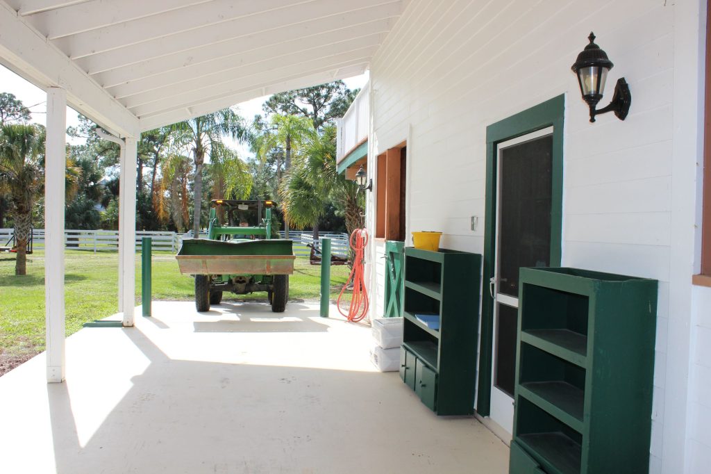 The porch area is tall and wide and allows the tractor to come to each stall for mucking.