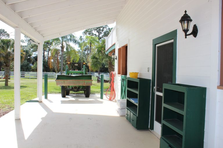 The porch area is tall and wide and allows the tractor to come to each stall for mucking.