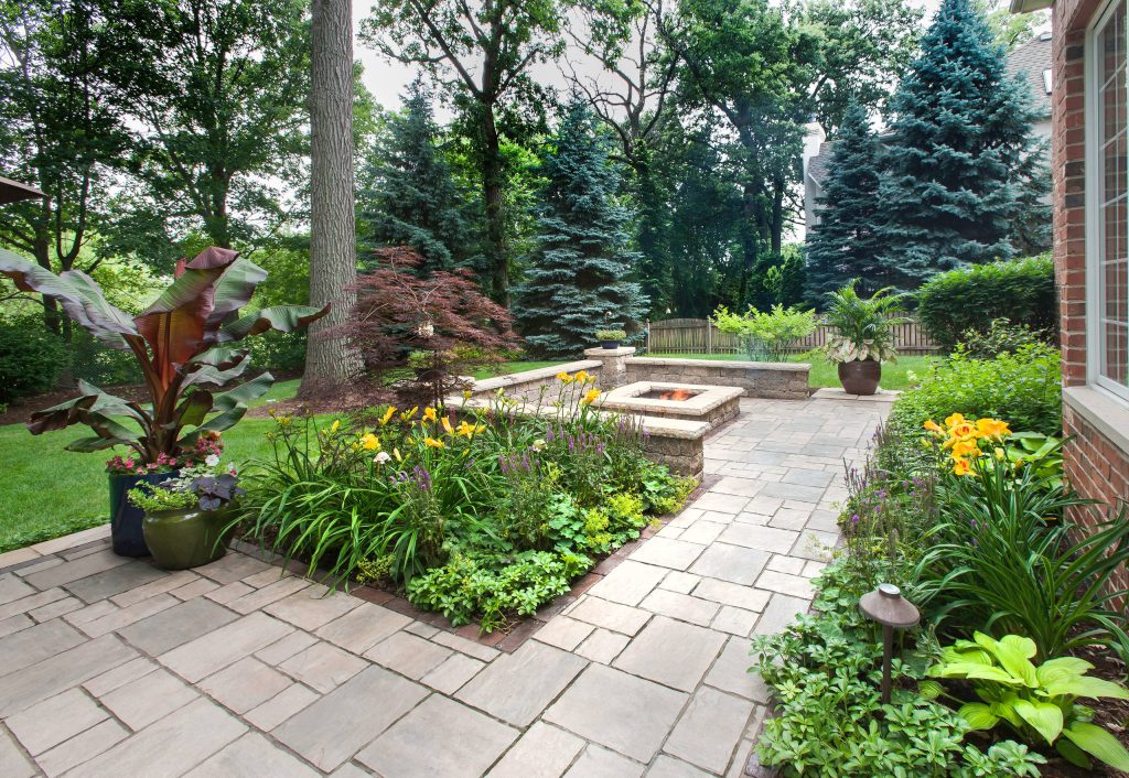 The primary patio space narrows into a walkway connecting to the fire pit. The planting beds on both side help define and separate the spaces. Photo courtesy of Mike Crews Photography. by KD Landscape | Backyard Design | Outdoor Living Spaces | Landscape Design | Backyard Ideas | Landscaping | Landscaping Ideas | Landscape Installation