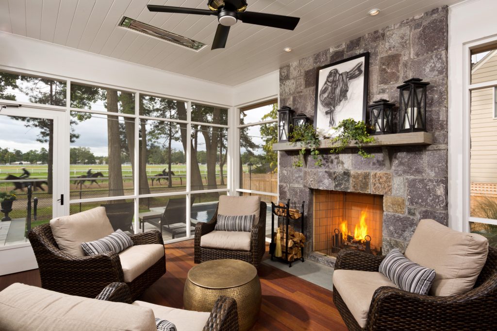 The screened porch boasts a wood burning fireplace for cozying up after a dip in the spa or watching the horses train on the track with a morning cup of coffee. by Teakwood Builders, Inc. | Outdoor Photos | Porch | Landscaping | Landscape Design | Outdoor Living Space | Porch Design Ideas | Outdoor Living Space Ideas | Backyard Design